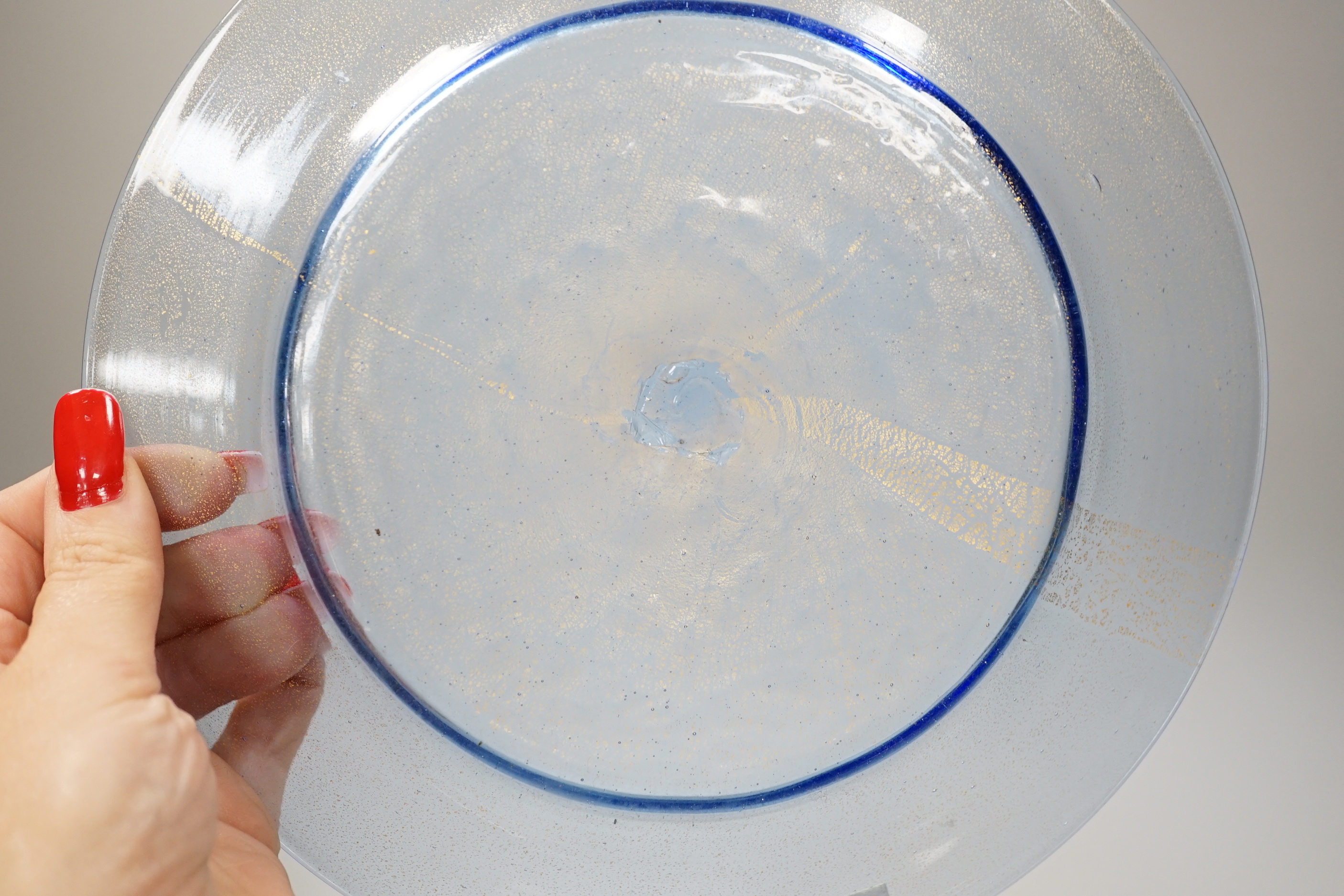 An antique Venetian / Facon de Venise plate, the metal has a bluish tinge with aventurine technique of blown gilding applied to the underside with radial bands concentrated in an artistic style, rough pontil to centre of